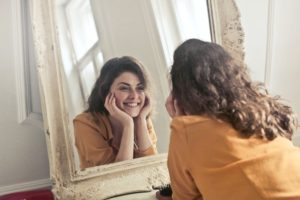 Women smiling at herself in mirror